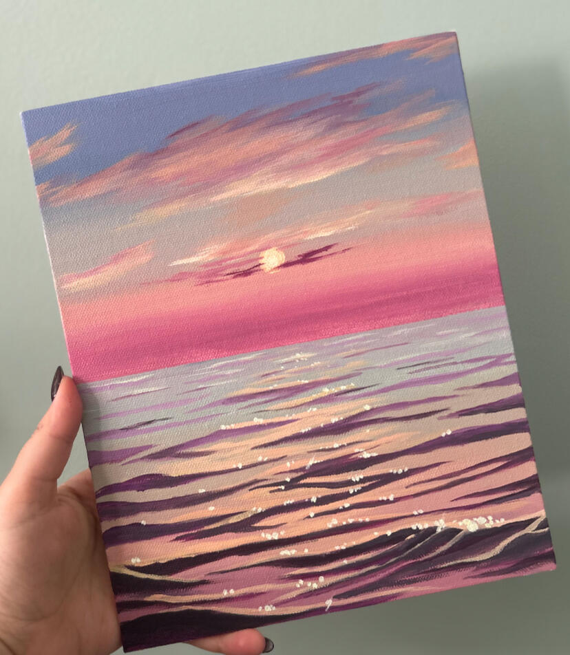 sunset pink sea seascape sunset painting held by hand.