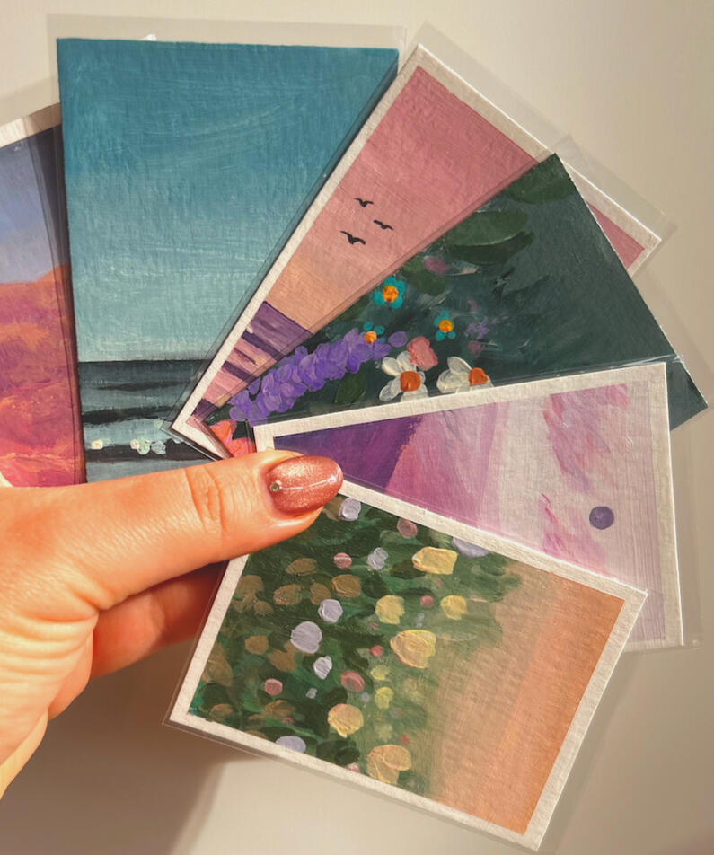 holding aceos hand holding 6 different aceo paintings in their protective sleeves